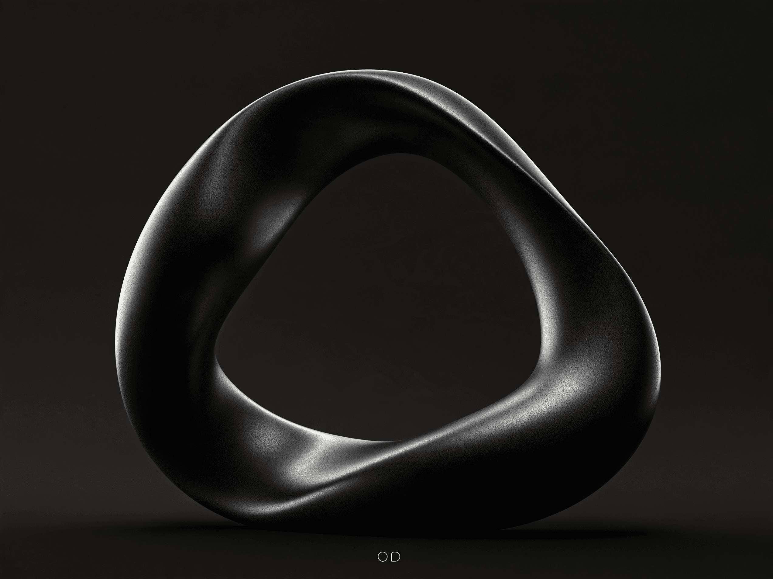 The Living O sculpture: a dark, satin ring on a graphite backdrop.
